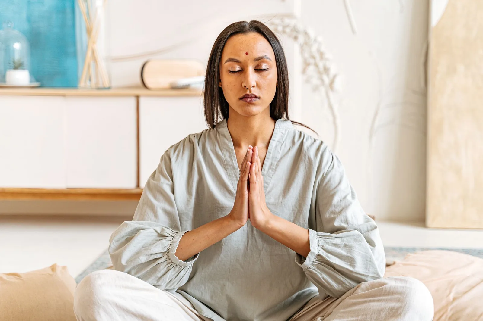 An Indian woman meditating in a bright, calm studio